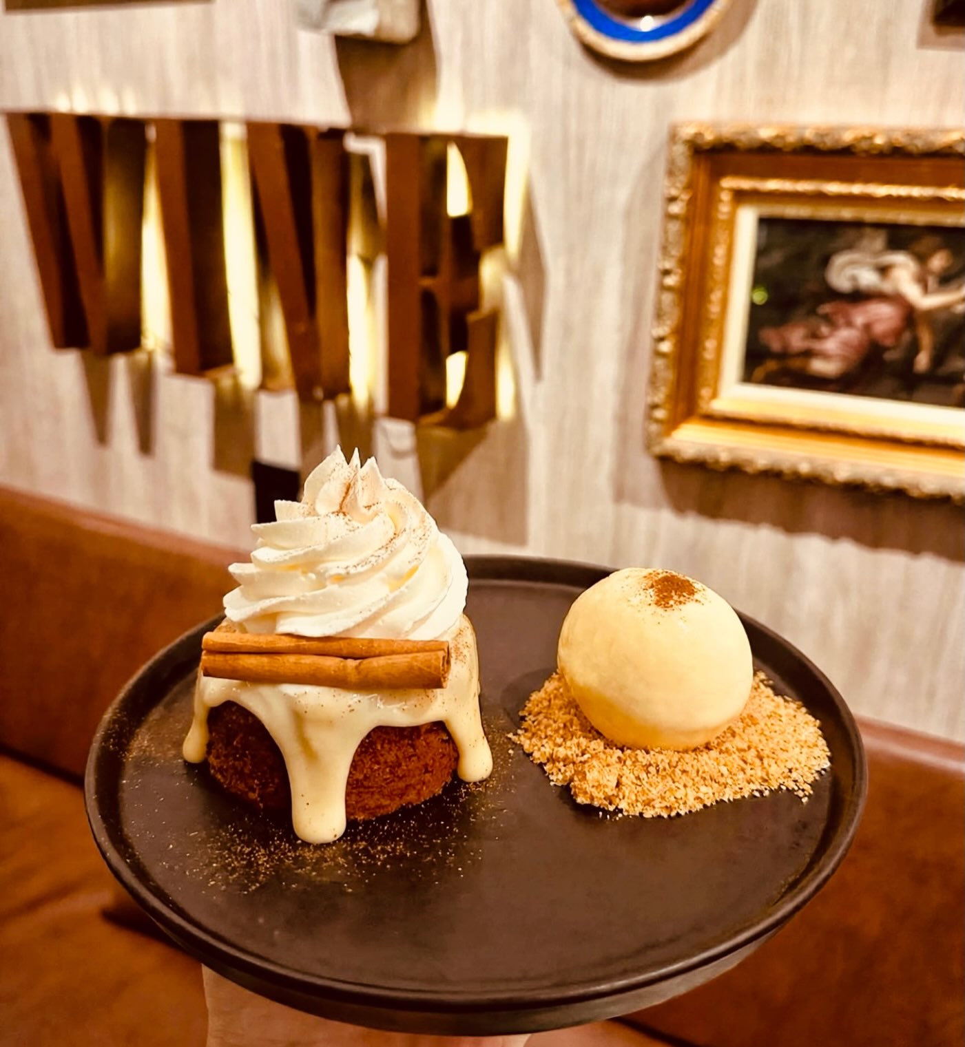 Bolinho de canela com chantilly, pau de canela e uma bola de sorvete